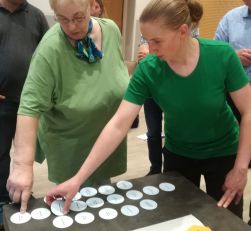 Zwei Damen in grünen Shirts ordnen Kreiskarten an.